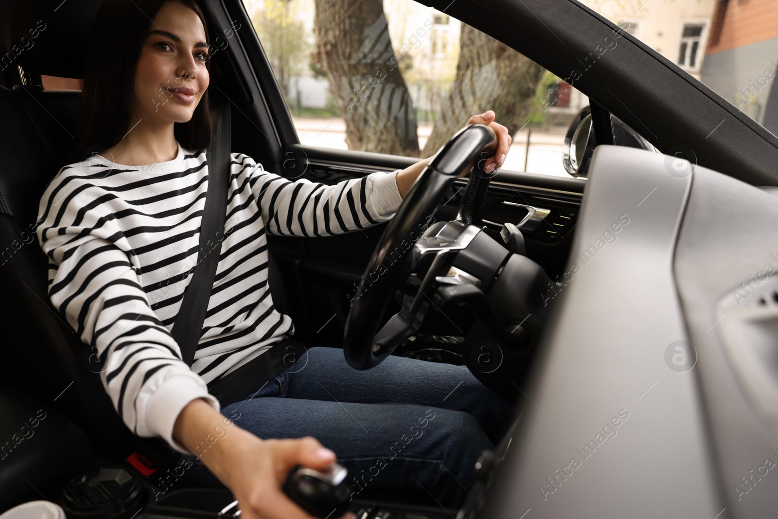 Photo of Woman with safety seat belt driving her modern car