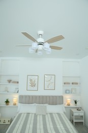 Photo of Ceiling fan, furniture and accessories in stylish bedroom