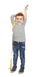 Photo of Little boy measuring his height on white background