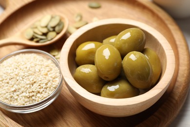 Photo of Products high in vegetable fats. Olives and sesame seeds on table, closeup