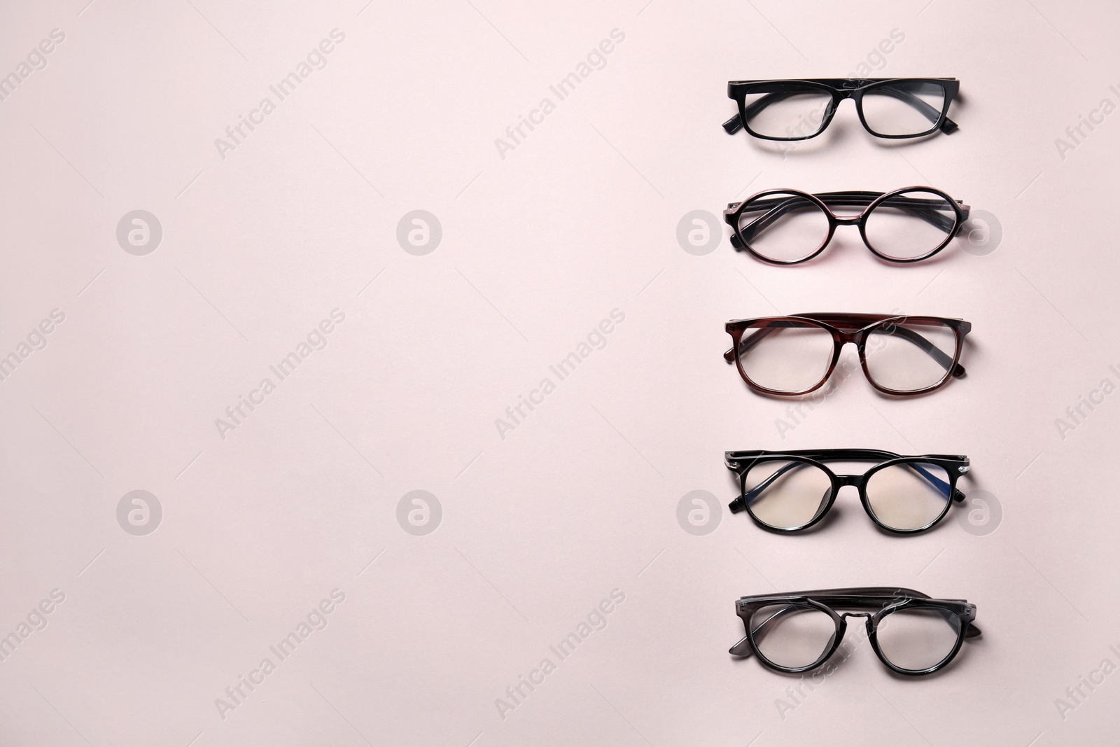 Photo of Many different stylish glasses on light grey background, flat lay. Space for text