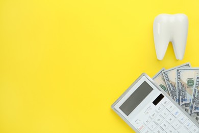 Photo of Ceramic model of tooth, dollar banknotes and calculator on yellow background, flat lay with space for text. Expensive treatment