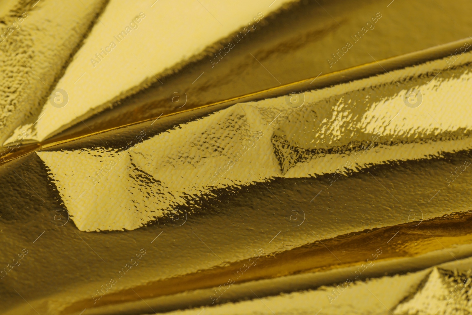 Photo of Edible gold leaf sheet as background, closeup