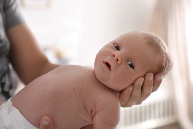 Photo of Father holding his little baby in bedroom