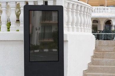 Photo of Multimedia touch information kiosk near white fence outdoors