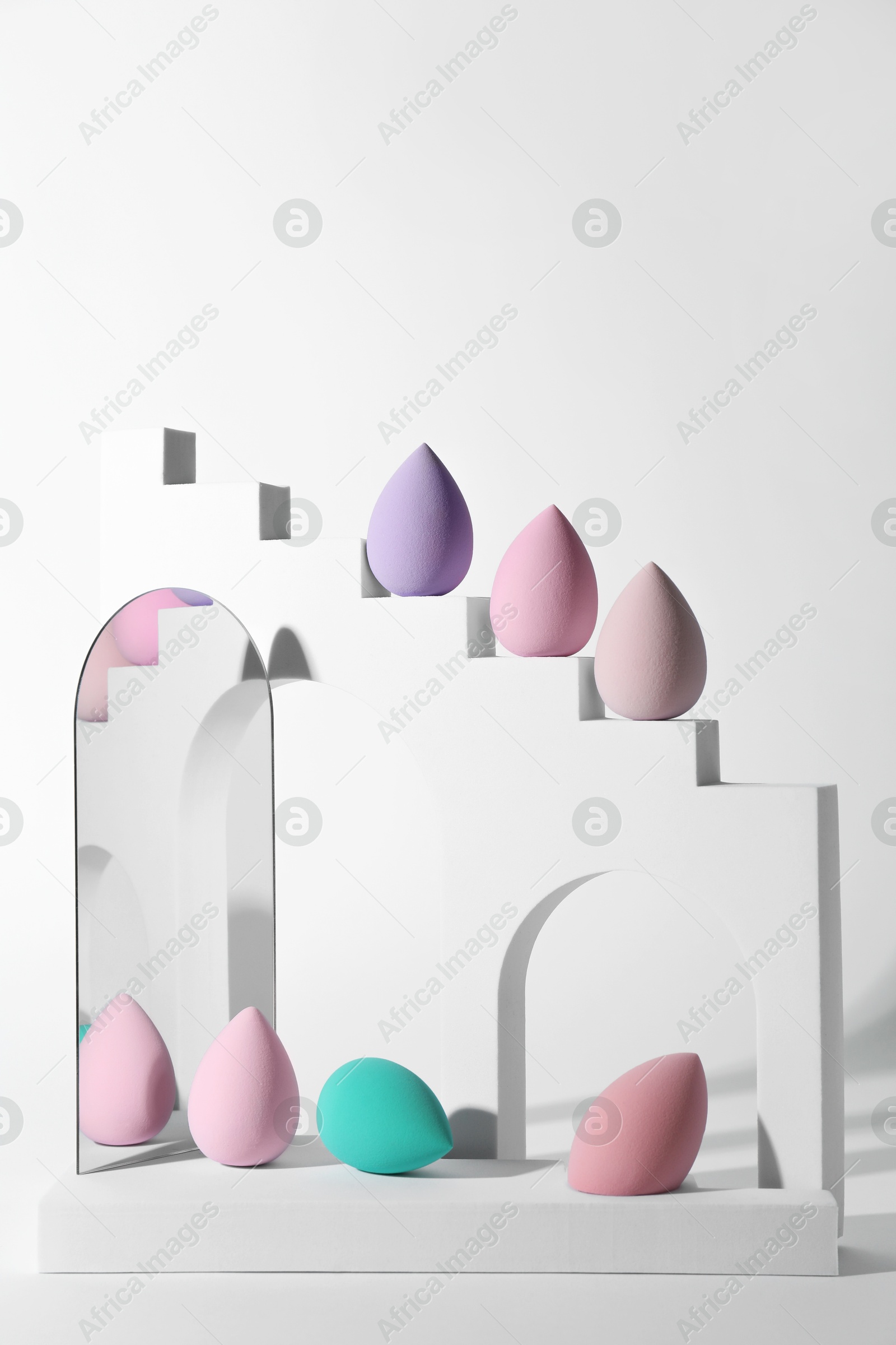 Photo of Stylish presentation of makeup sponges on white background