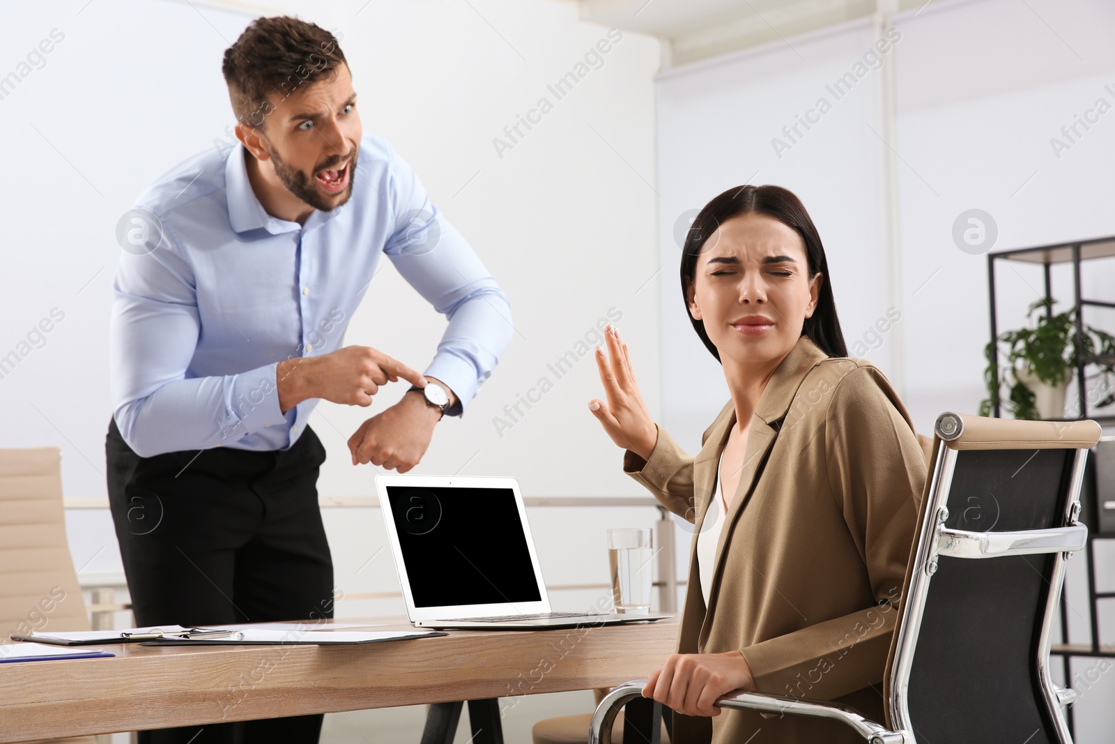 Photo of Boss screaming at employee in office. Toxic work environment