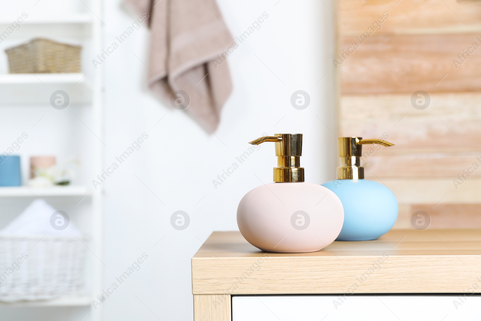 Photo of Stylish soap dispensers on table against blurred background. Space for text