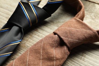Photo of Two neckties on light wooden table, closeup