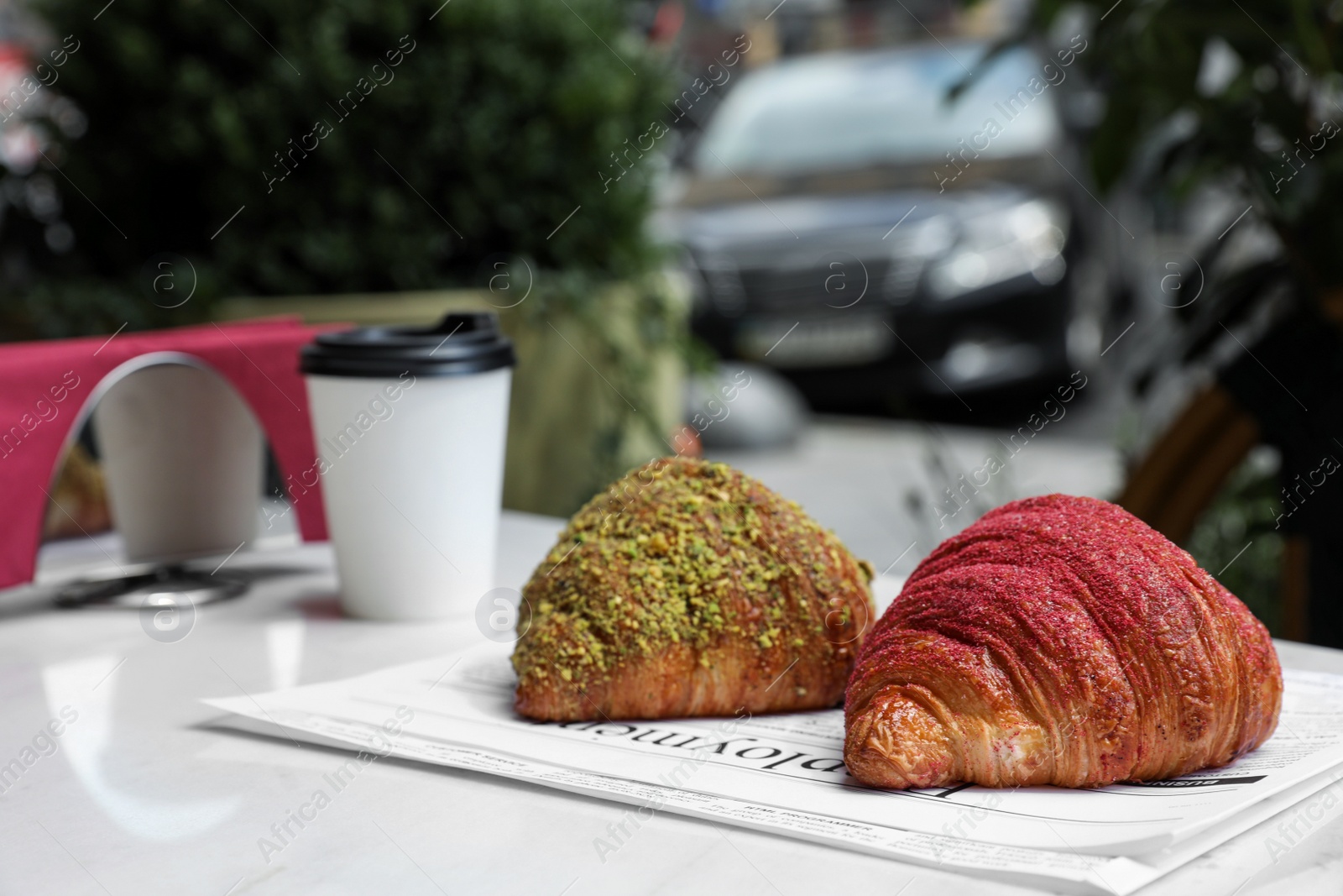 Photo of Delicious croissants and paper cup of coffee on white table