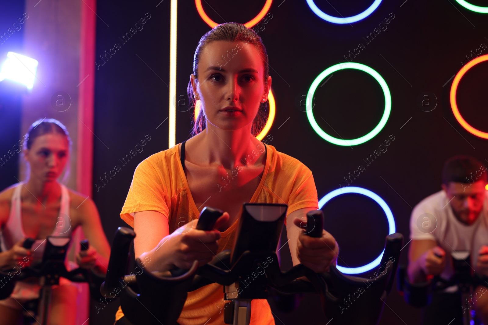 Photo of Group of people training on exercise bikes in fitness club