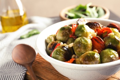 Bowl of warm salad with Brussels sprouts and carrots on table