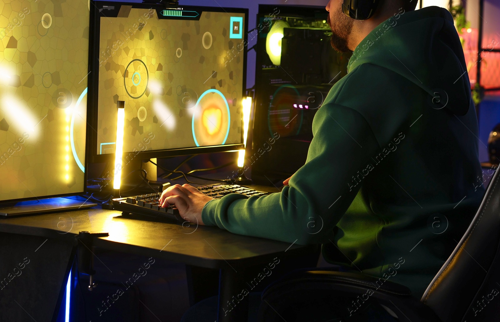 Photo of Man playing video games on computer at table indoors