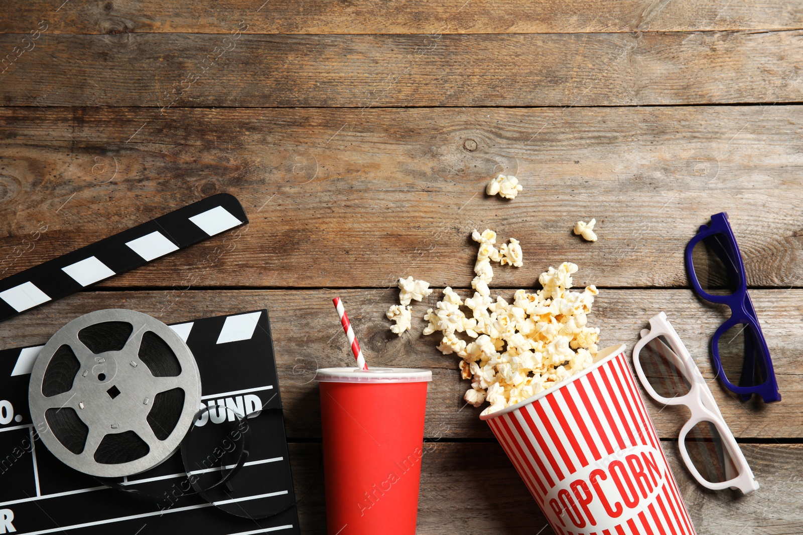 Photo of Flat lay composition with clapper, popcorn and space for text on wooden background. Cinema snack