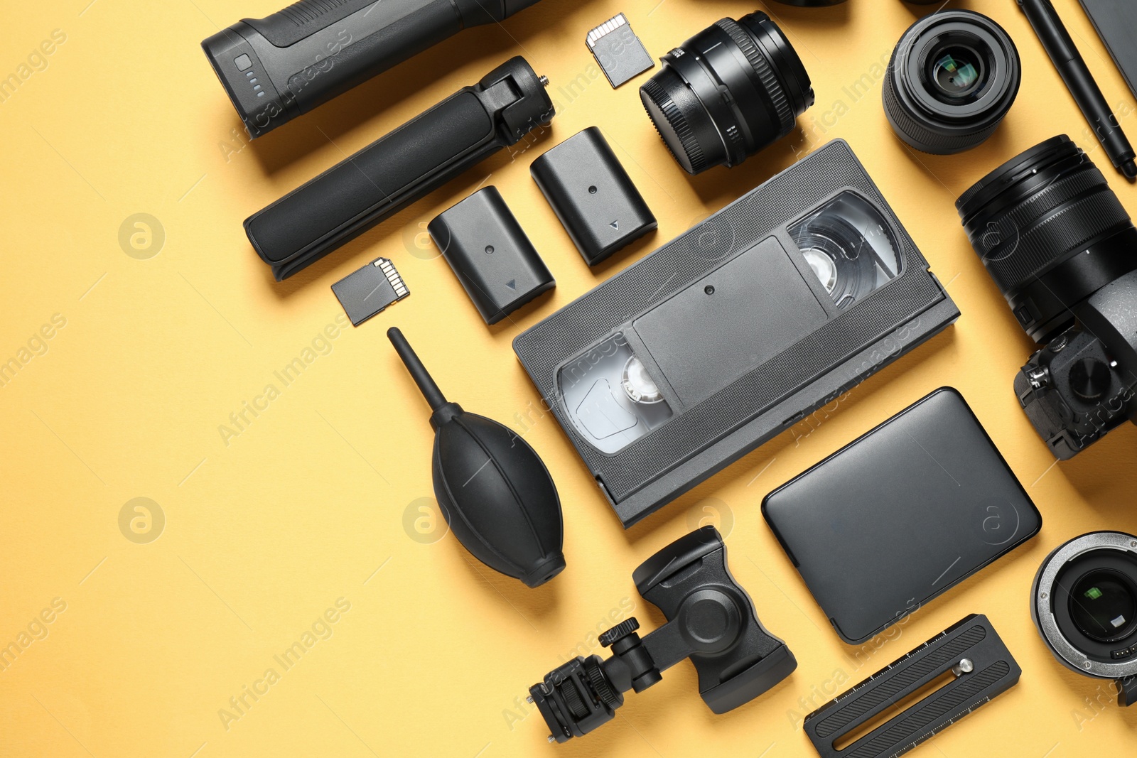 Photo of Flat lay composition with camera and video production equipment on yellow background. Space for text