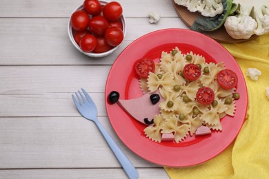 Photo of Creative serving for kids. Plate with cute hedgehog made of delicious pasta, sausages and tomatoes on white wooden table, flat lay. Space for text
