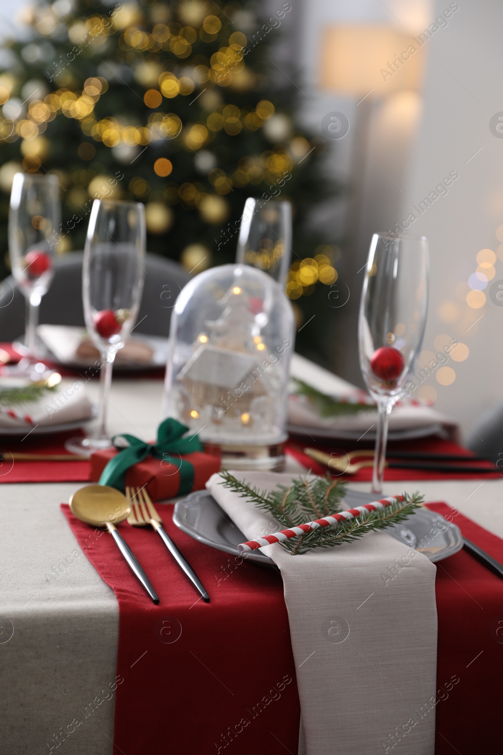 Photo of Christmas table setting with festive decor and dishware indoors