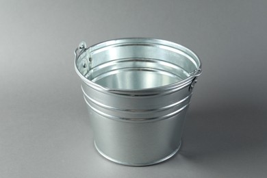 Photo of One shiny metal bucket on light grey background