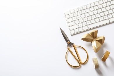 Composition with scissors, keyboard and gold butterfly on white background, top view