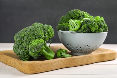 Photo of Fresh raw broccoli on white wooden table, closeup