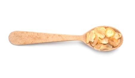 Photo of Wooden spoon with dried garlic flakes on white background. Different spices