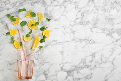 Creative lemonade layout with lemon slices, mint and ice on white marble table, top view. Space for text