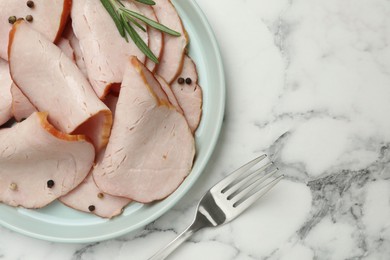 Photo of Delicious cut ham with rosemary and peppercorns served on white marble table, flat lay. Space for text