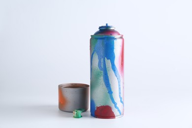 Photo of One spray paint can and cap on white background