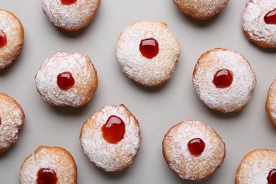 Photo of Hanukkah donuts with jelly and powdered sugar on light grey background, flat lay