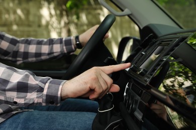 Photo of Driver using modern car navigation system, closeup