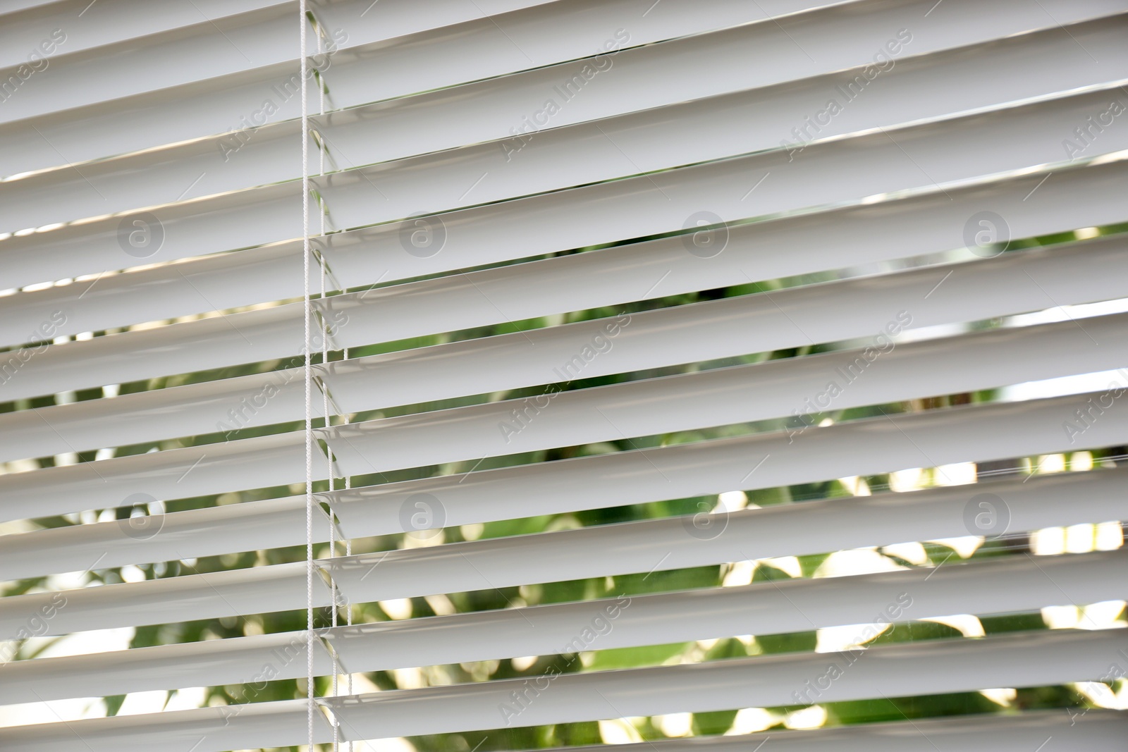 Photo of Open white horizontal window blinds, closeup view