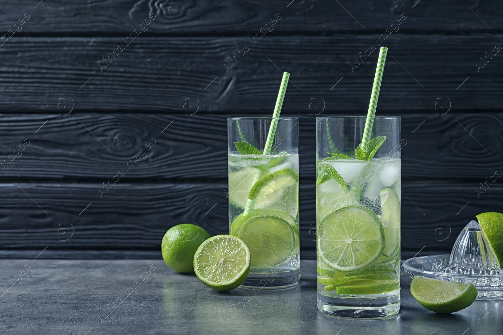 Photo of Glasses of natural lemonade with lime on table