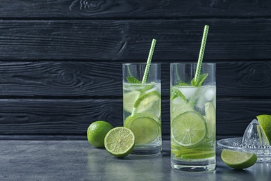 Photo of Glasses of natural lemonade with lime on table