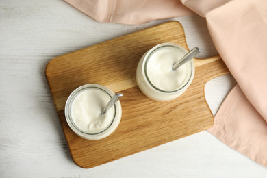 Photo of Tasty organic yogurt on white wooden table, flat lay