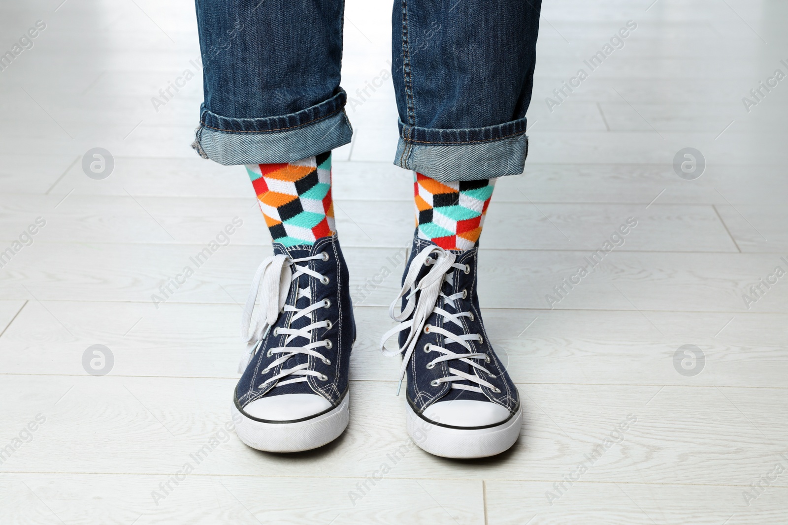 Photo of Person wearing stylish socks and shoes on floor, closeup