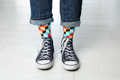 Person wearing stylish socks and shoes on floor, closeup