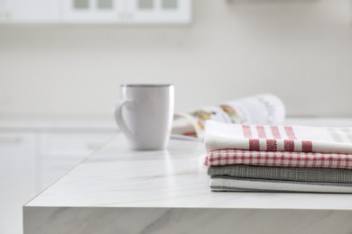 Photo of Stack of kitchen towels on white marble table. Space for text