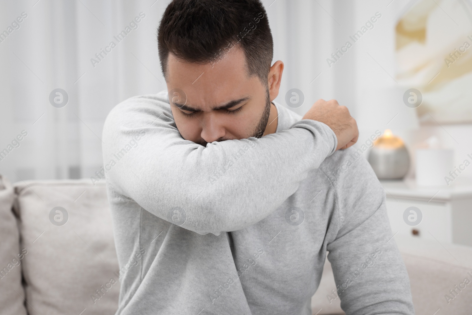 Photo of Sick man coughing at home. Cold symptoms