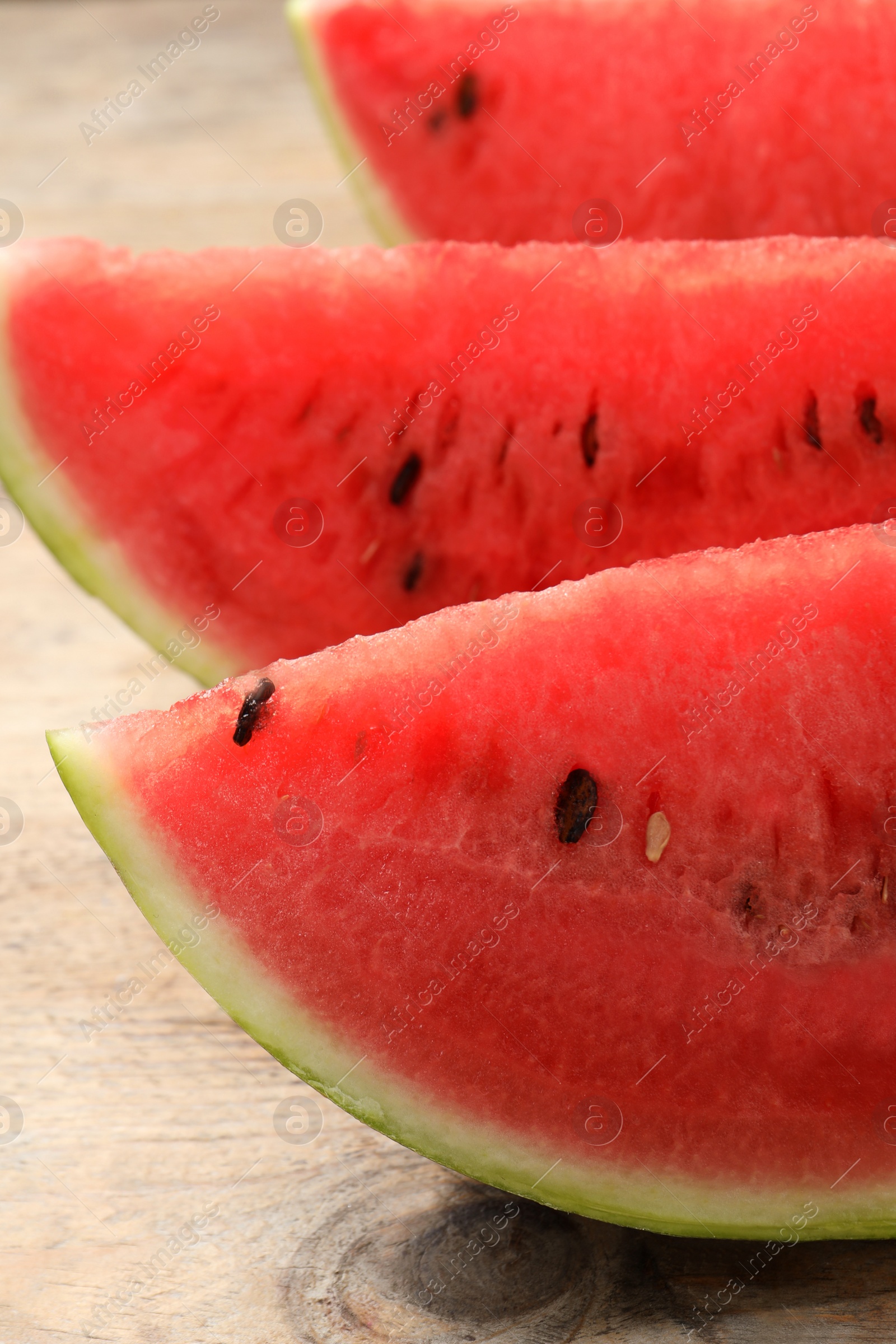 Photo of Slices of tasty ripe watermelon on wooden table, closeup