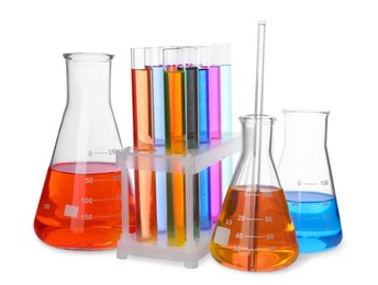 Photo of Test tubes and other laboratory glassware with colorful liquids on white background