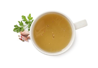 Hot delicious bouillon in cup and ingredients on white background, top view