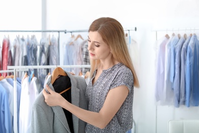 Young woman with jacket at dry-cleaner's