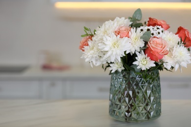 Photo of Vase with beautiful flowers on table in kitchen, space for text. Interior design