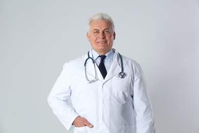 Photo of Portrait of senior doctor against light background. Medical service