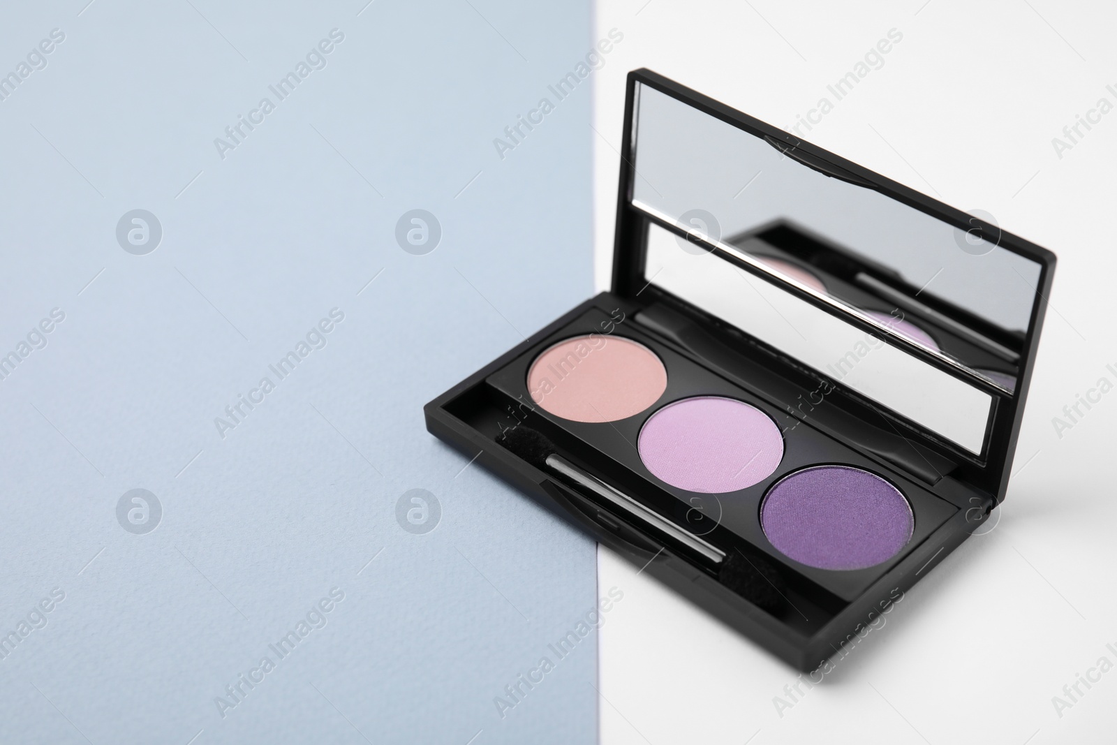 Photo of Eye shadow palette on colorful background, closeup. Space for text