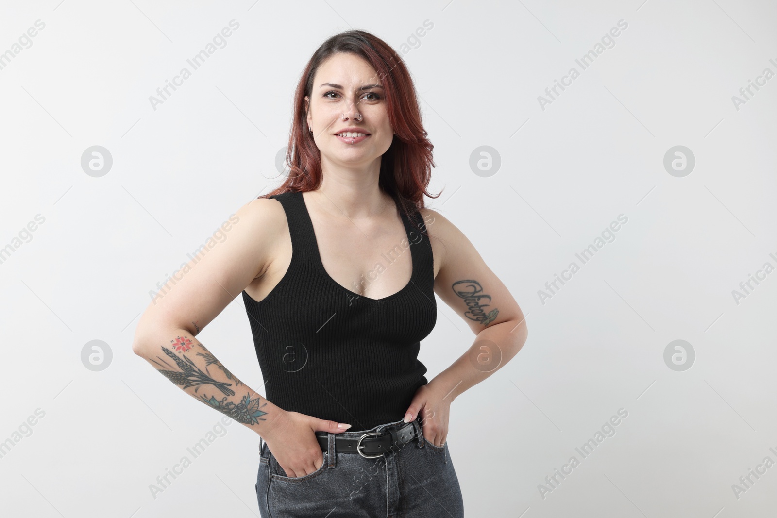 Photo of Portrait of beautiful tattooed woman on gray background