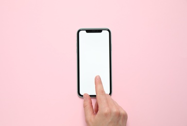 Photo of MYKOLAIV, UKRAINE - JULY 07, 2020: Woman using iPhone 11 on pink background, top view. Mockup for design