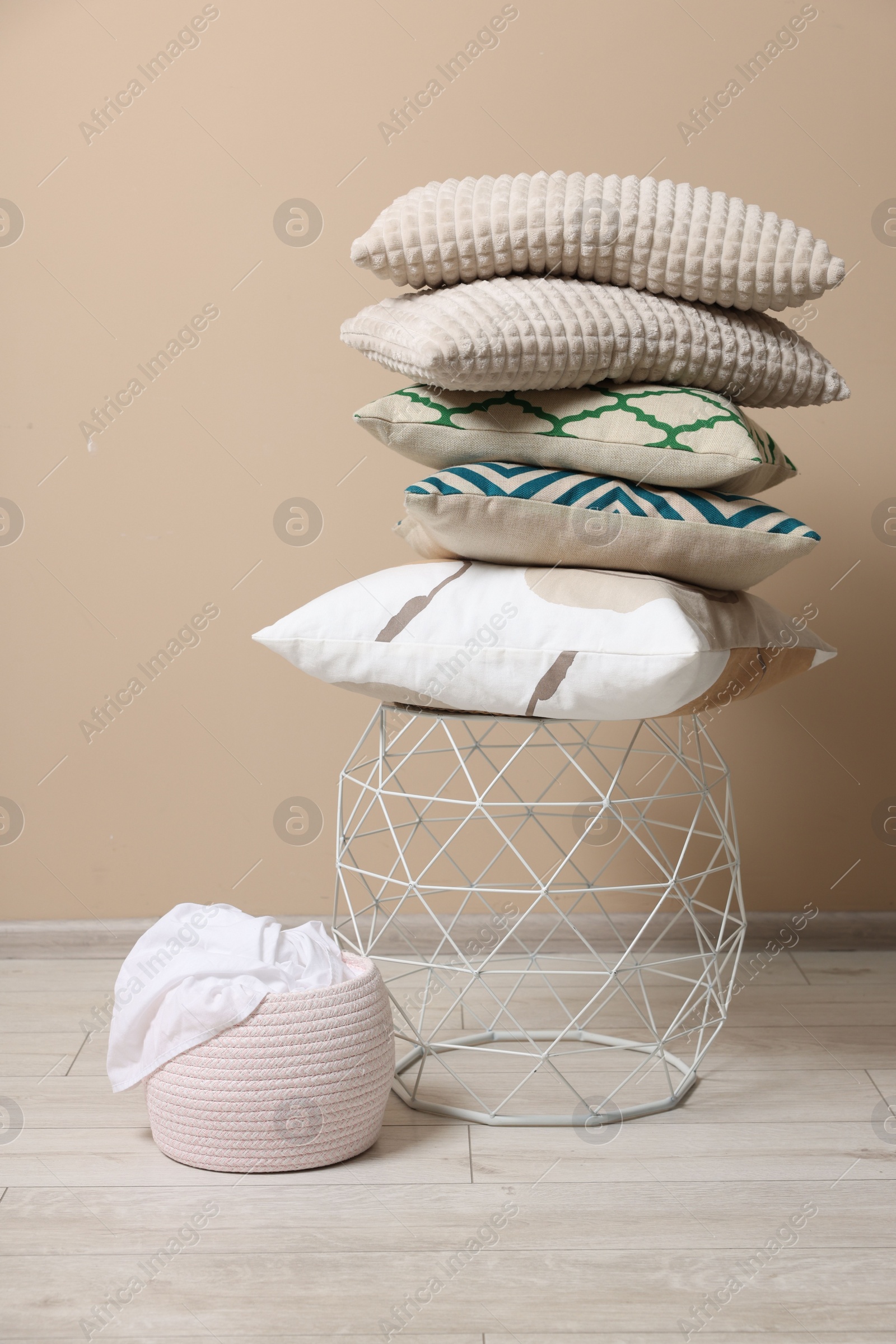 Photo of Stack of soft pillows on small table indoors