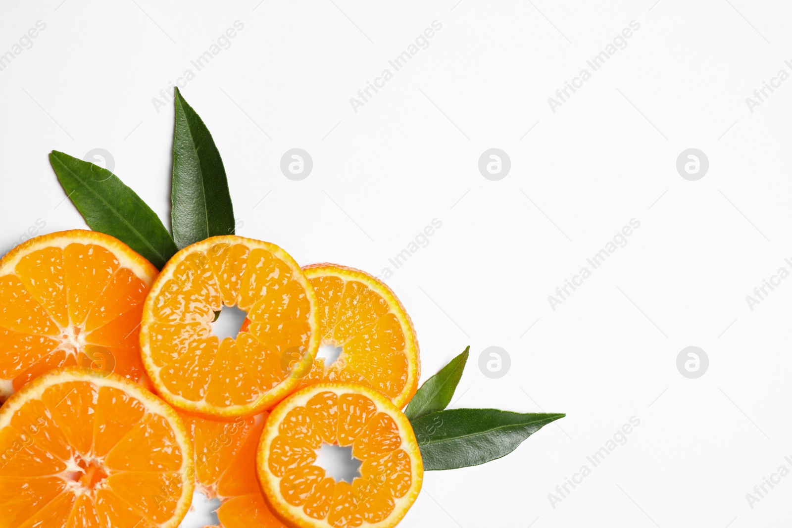 Photo of Composition with slices of fresh ripe tangerines and leaves on white background, top view. Citrus fruit