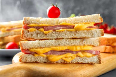 Photo of Tasty sandwiches with ham, melted cheese and tomato on table, closeup